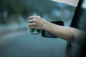 driver holding a beer can out the window