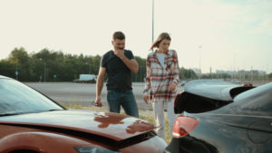 man and woman surveying a car accident