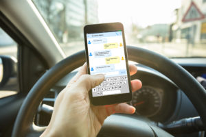 close-up of person’s phone while they’re texting while driving