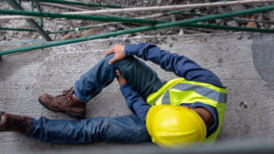 construction worker holding his knee after a fall