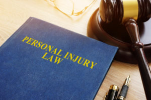 personal injury law book a pair of glasses and a gavel sit on a desk