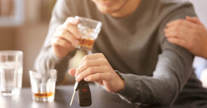 A person drunk on whiskey holding car keys